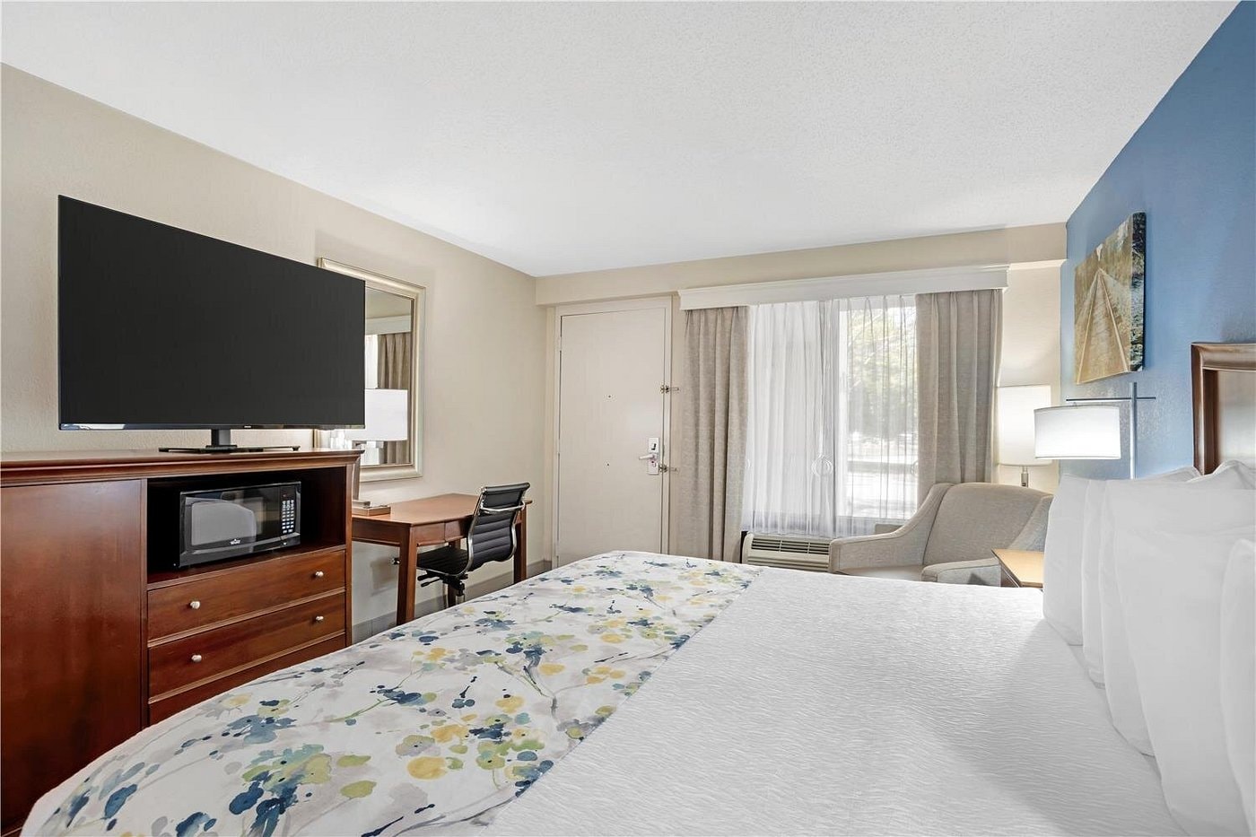 King bed guest room at Best Western Monroe — blue accent wall, wood headboard