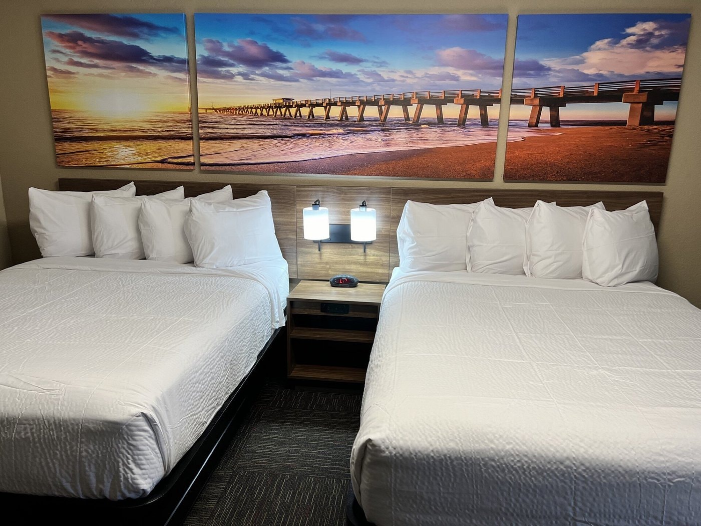 Double queen room at Days Inn Monroe — beach pier artwork above beds