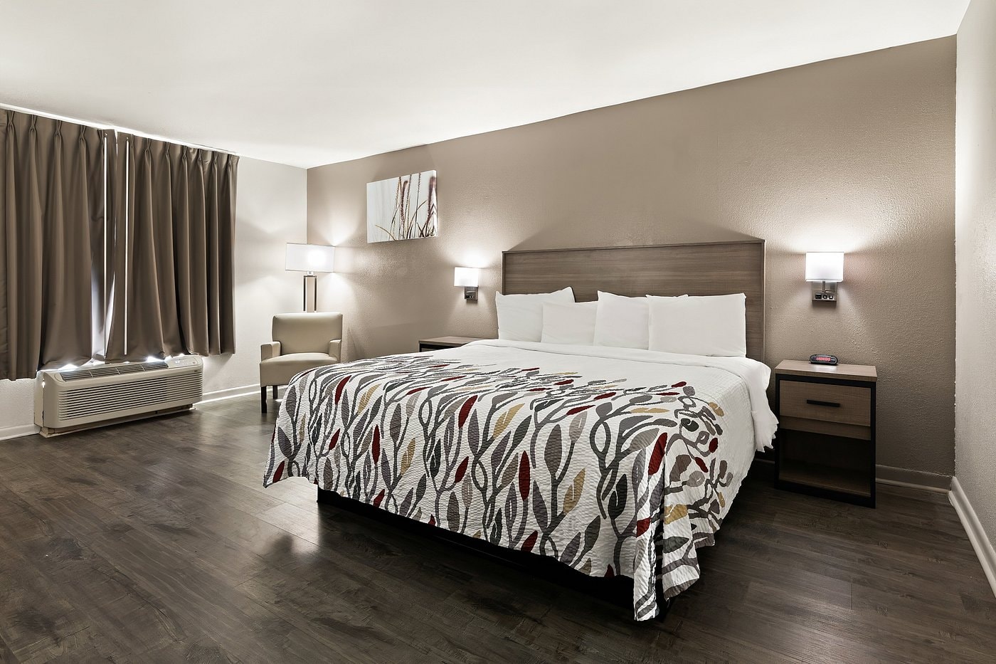 ADA Deluxe King room at Red Roof Inn Monroe — taupe walls, dark wood floors, patterned bedding