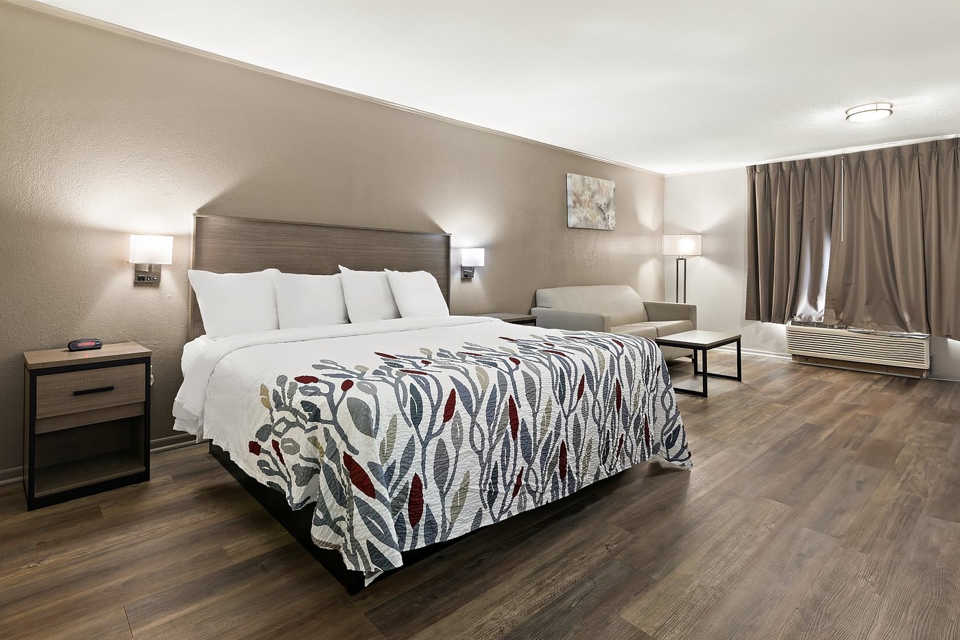Superior King room at Red Roof Inn Monroe — king bed with sofa and hardwood floors